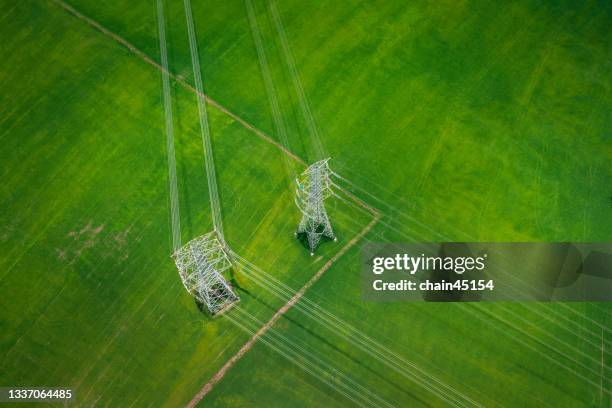 aerial view of the high voltage power lines and high voltage electric transmission over rice fields in rural country. - hochspannungsmast stock-fotos und bilder