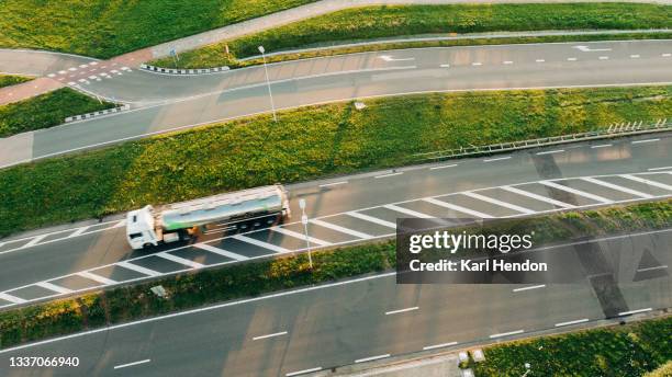 an aerial view of a truck on a road at sunset - stock photo - grünstreifen stock-fotos und bilder