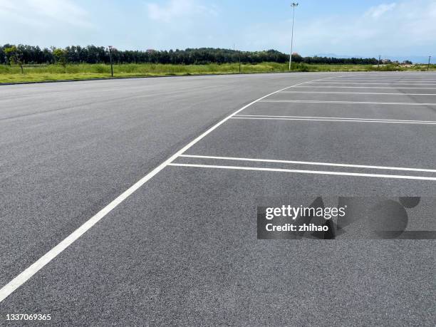 empty asphalt parking lot - parkplatz stock-fotos und bilder