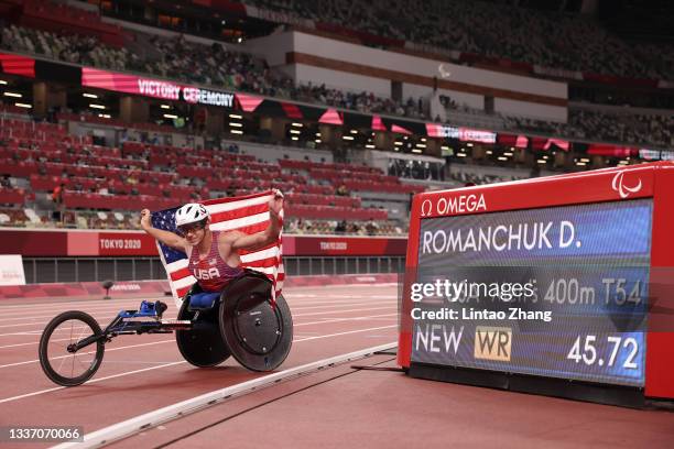 Daniel Romanchuk of Team United States celebrates with his national flag after breaking the world record and winning gold in Men's 400m - T54 on day...