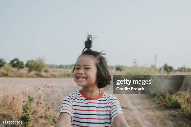 cara feliz de la chica local tailandesa a lo largo de la granja de arroz para obtener aire fresco - foto de archivo - thai ethnicity fotografías e imágenes de stock