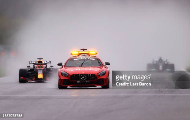 The FIA Safety Car leads Max Verstappen of the Netherlands driving the Red Bull Racing RB16B Honda and the rest of the field at the restart during...