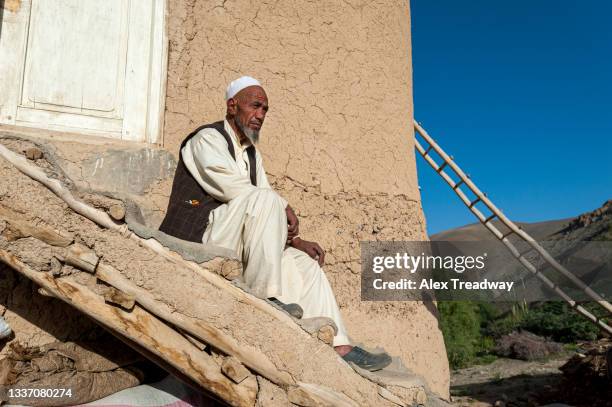 a farmer surveys his fields early in the morning outside his house in fulladi valley in the bamiyan province of afghanistan - afghan old man stock pictures, royalty-free photos & images