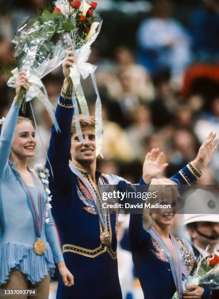 Bronze medalists Jill Watson and Peter Oppegard of the USA and gold medalist Ekaterina Gordeeva of the USSR wave to the crowd during the awards...