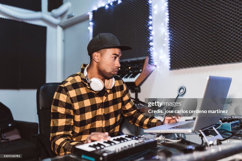 Music producer in recording studio, composing base, producing music