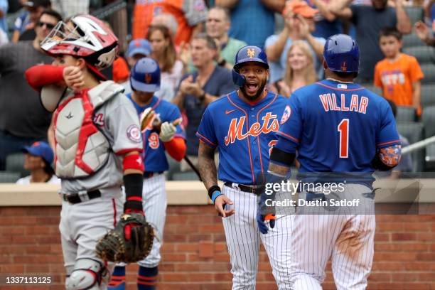 Dominic Smith greets Jonathan Villar of the New York Mets at home plate after Villar hit a home run during the bottom of the sixth inning of a game...