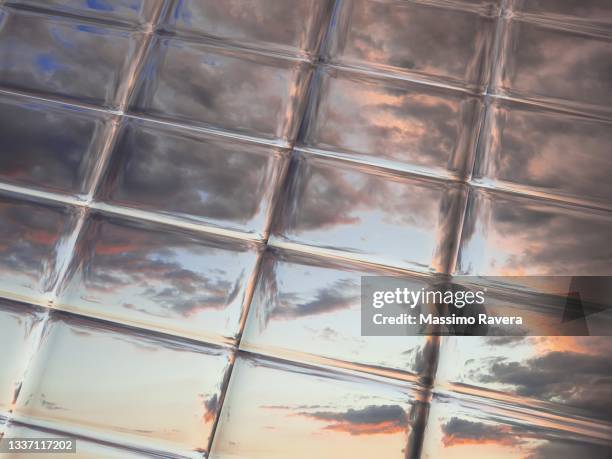 metallic reflection of sky full of clouds - chroom stock-fotos und bilder