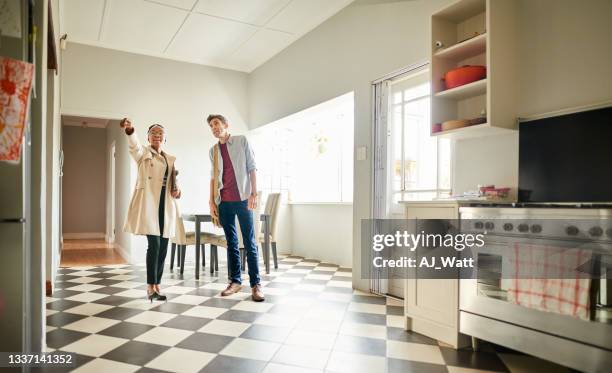 real estate agent talking with a client in the kitchen of a house for sale - house inspection stock pictures, royalty-free photos & images