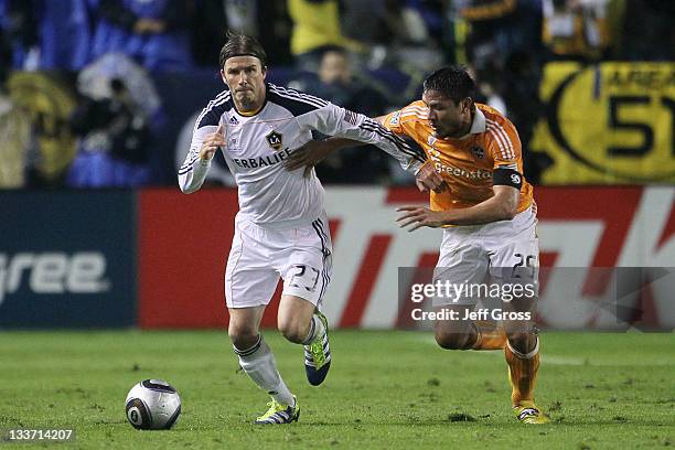 David Beckham of the Los Angeles Galaxy controls the ball against Brian Ching of the Houston Dynamo during the 2011 MLS Cup at The Home Depot Center...