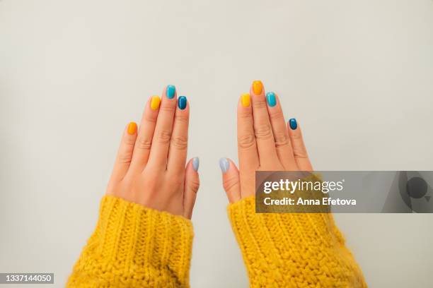 trendy bright manicure on woman hands in illuminating yellow knitted sweater against ultimate gray background. trendy colors of the year 2021. flat lay style. close-up - sleeve fotografías e imágenes de stock