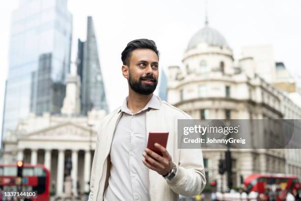 indian man walking through london’s financial district - city of london stockfoto's en -beelden