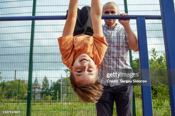 großvater und enkel treiben gemeinsam sport - reck stock-fotos und bilder