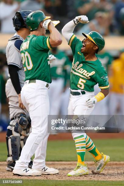 Tony Kemp of the Oakland Athletics celebrates with Mark Canha after hitting a two-run home run in the bottom of the eighth inning against the New...