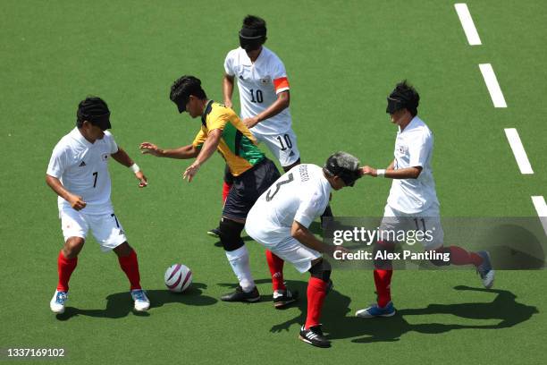 Players of Team Japan struggle to stop Tiago da Silva of Team Brazil during the 5-a-side football match between Team Brazil and Team Japan at the...