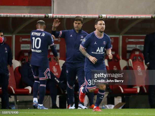 Lionel Messi of PSG is replacing Neymar Jr, left with coach of PSG Mauricio Pochettino during the Ligue 1 Uber Eats match between Stade Reims and...