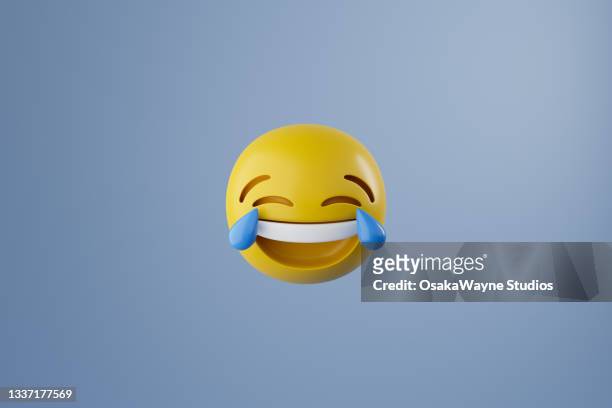 laughing face emoticon with big blue tears at eyes - lachen stockfoto's en -beelden