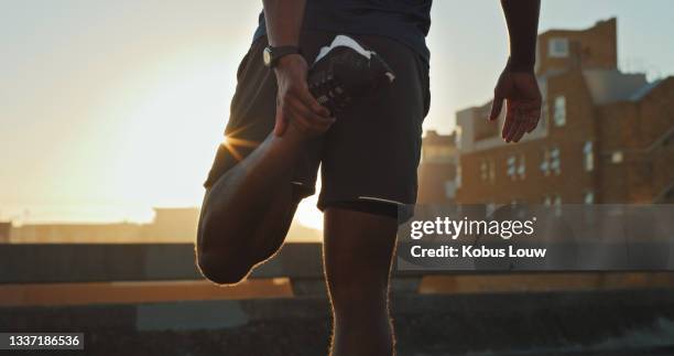 scatto ravvicinato di un uomo irriconoscibile che allunga le gambe mentre si allena all'aperto - fare lo stretching foto e immagini stock