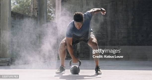 tiro de um jovem esportivo exercitando-se com uma chaleira - kettlebell - fotografias e filmes do acervo