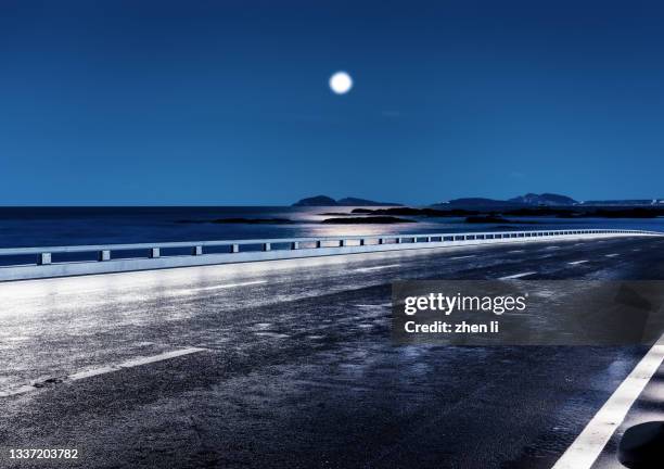 coastal road at night - mondlicht stock-fotos und bilder