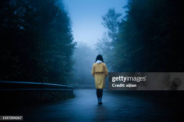 lonely woman is walking on fog road - lost stock pictures, royalty-free photos & images