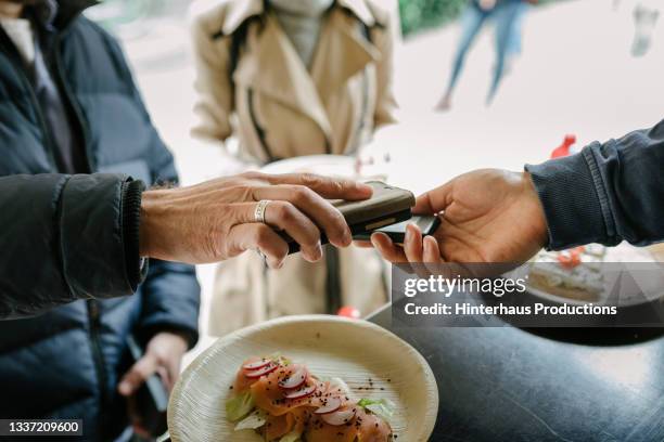man paying for order using contactless at food truck - homens de idade mediana imagens e fotografias de stock