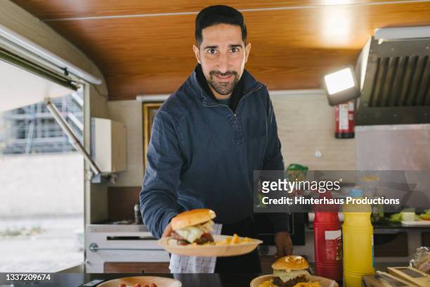 chef passing burger to customer from food truck - 35 39 jahre stock-fotos und bilder