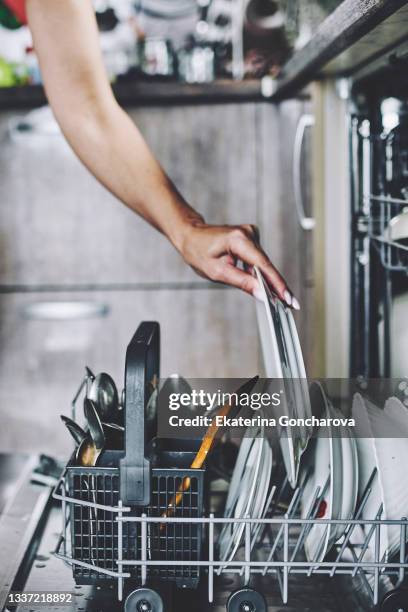 cleaning dishes in the dishwasher. - unloading stockfoto's en -beelden