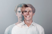 Multiple exposure portrait of young european caucasian man with positive smile and serious sad facial expression. Mental health, depression and emotions concept.