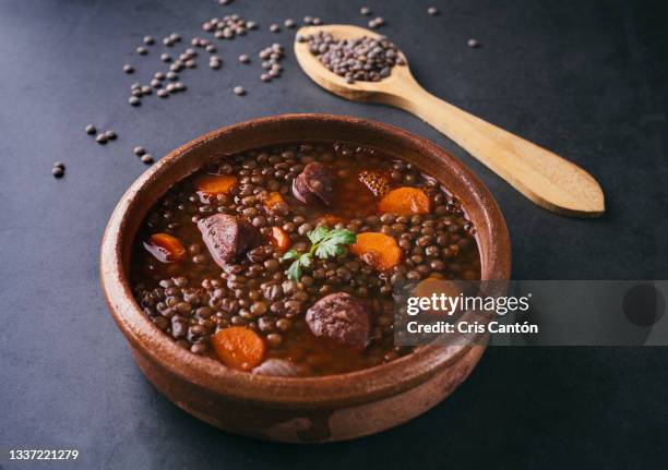 lentils soup with chorizo on black background - lentils stock pictures, royalty-free photos & images