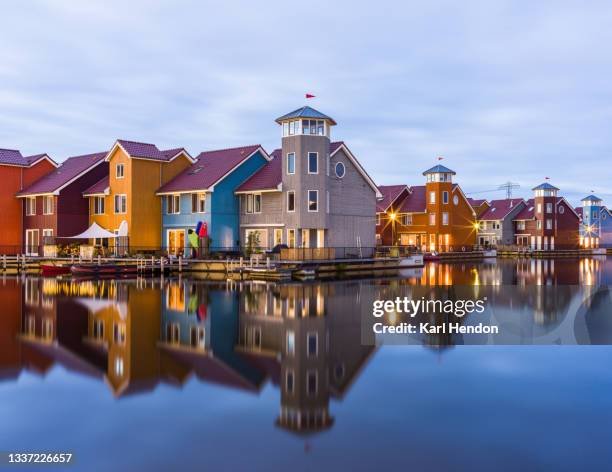 colourful waterfront apartments at dusk - stock photo - groningen stad stockfoto's en -beelden