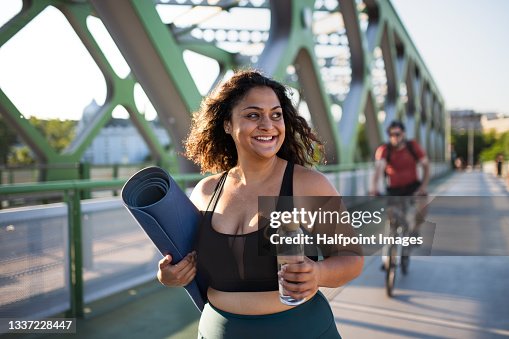 Portrait of beautiful young overweight woman walking outdoors on bridge in city, exercise concept. Portrait of beautiful young overweight woman walking outdoors on bridge in city, exercise concept.