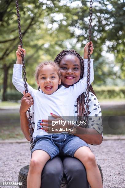 mother and son having fun on a swing - woman on swing stock pictures, royalty-free photos & images