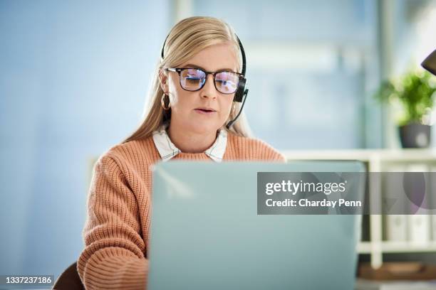foto de una joven trabajando en un call center - call center serious fotografías e imágenes de stock
