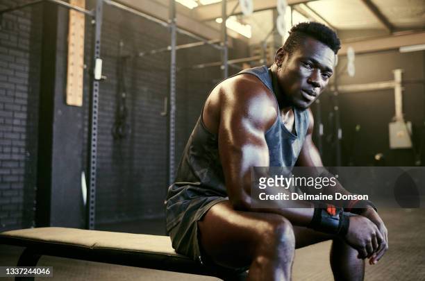 portrait of a young fit sweaty man sitting in the gym after his workout - muscle building stockfoto's en -beelden