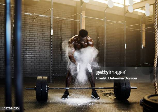 shot of a young attractive man powdering his hands in preparation of lifting  barbell at the gym - intensidade de cores imagens e fotografias de stock