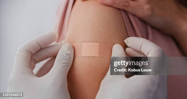 cropped shot of an unrecognizable doctor putting a band-aid on his patient after giving her an injection - woman injecting stock pictures, royalty-free photos & images