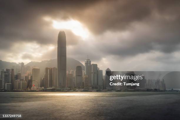 the traditional ferry boat crosses victoria harbor from kowloon to the hong kong island,skyscrapers of downtown in background.kowloon, hong kong, china. - centro de convenção e exposição de hong kong - fotografias e filmes do acervo