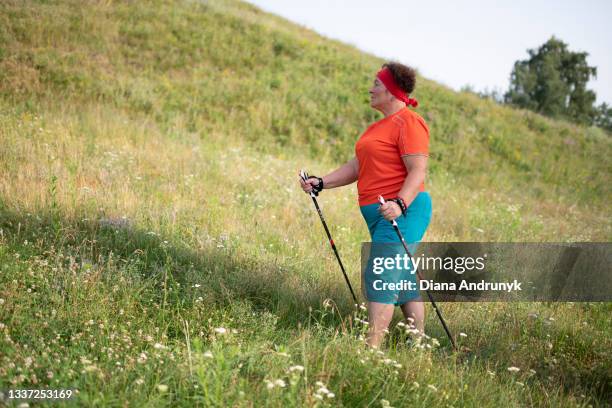 mature woman is engaged in nordic walking - archosargus stock pictures, royalty-free photos & images