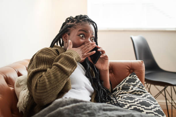 shot of a young woman on a call at home - black woman phone shock stock pictures, royalty-free photos & images