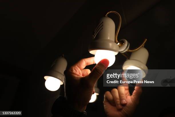 Person changes a light bulb, the day on which the price of light beats an all-time record by reaching 124.45 euros per megawatt hour, on August 30 in...