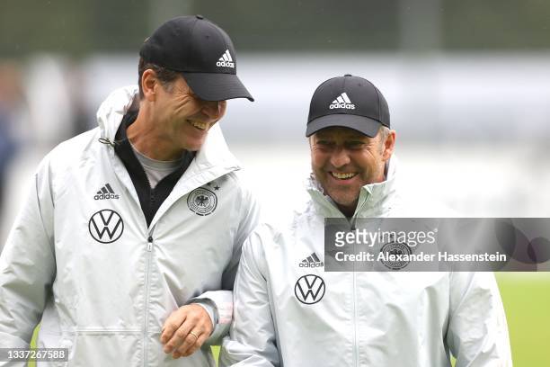 Hans-Dieter Flick, Head Coach of Germany talks to Oliver Bierhoff DFB director for national teams and the DFB academy during a training session at...