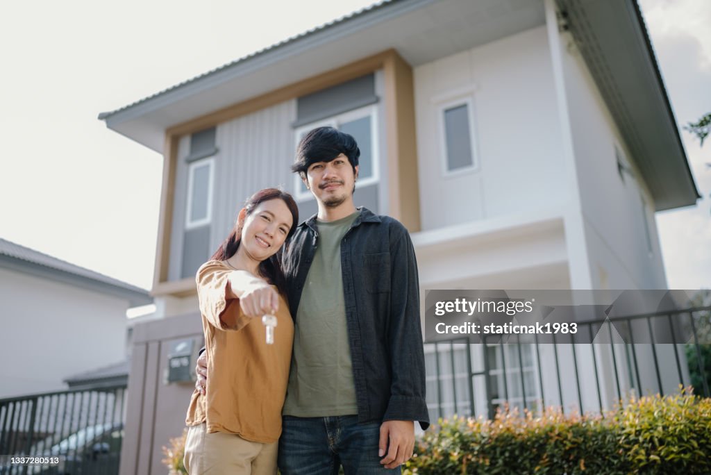 Couple holding house keys.