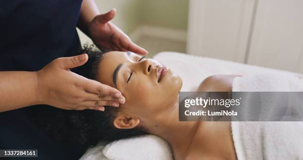 scatto di una donna che riceve un massaggio in una spa - head massage foto e immagini stock