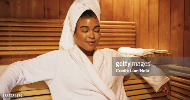 shot of a beautiful young woman relaxing in a sauna at a spa - hälsosalong bildbanksfoton och bilder