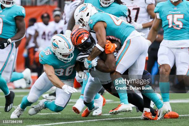 Joe Mixon of the Cincinnati Bengals runs with the ball while being tackled by Nate Holley and Nik Needham of the Miami Dolphins in the first quarter...
