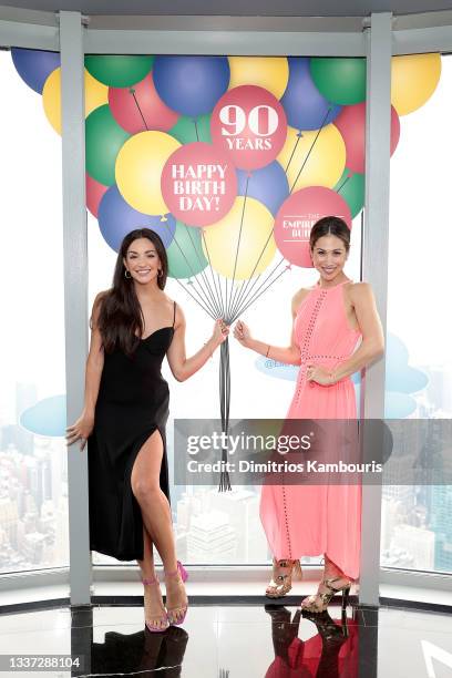 Ana Villafañe and Bianca Marroquín light The Empire State Building red in honor of the return of Broadway, on August 30, 2021 in New York City.