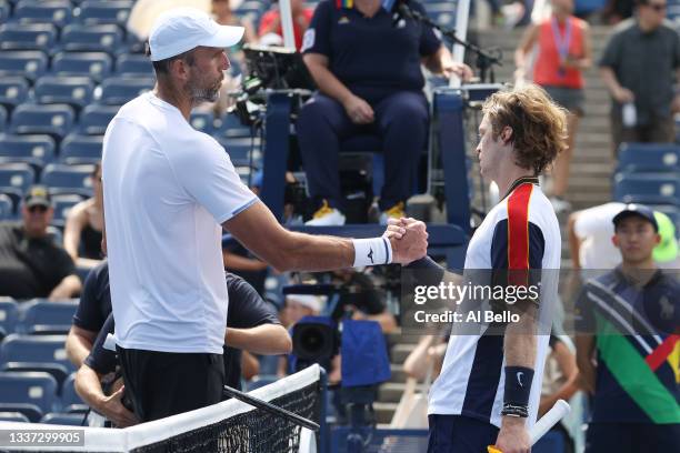 Andrey Rublev of Russia shake hands Ivo Karlovic of Croatia following their men's singles first round match on Day One of the 2021 US Open at the...