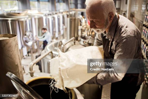 arbeiter, der die hopfenernte in einen tank lädt - hopfen malz stock-fotos und bilder