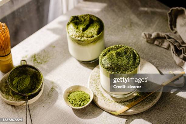 glass of dalgona iced matcha tea - matcha tea stock pictures, royalty-free photos & images