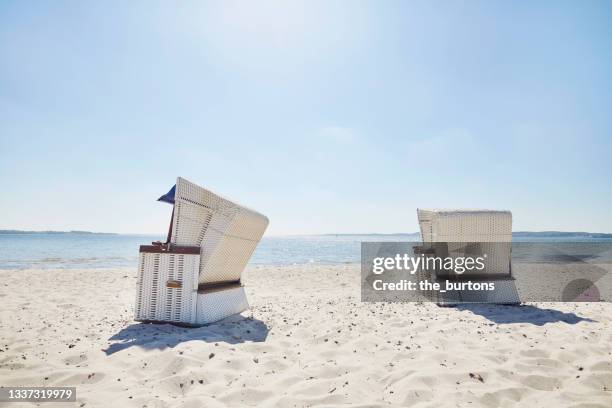 wicker beach chair at beach against blue sky - silla de playa con toldo fotografías e imágenes de stock